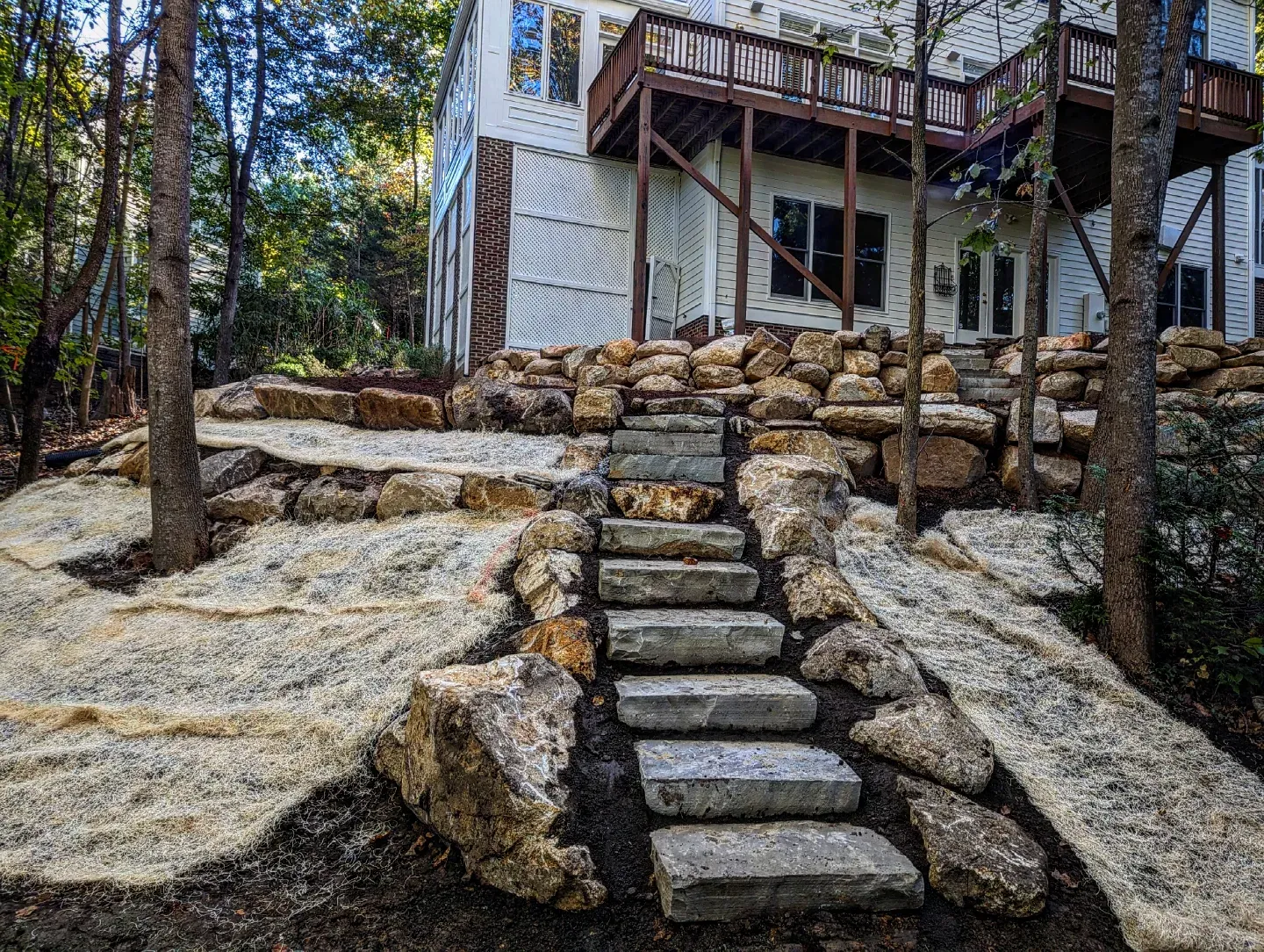 Boulder stairway flanked by plantings leading through a terraced yard