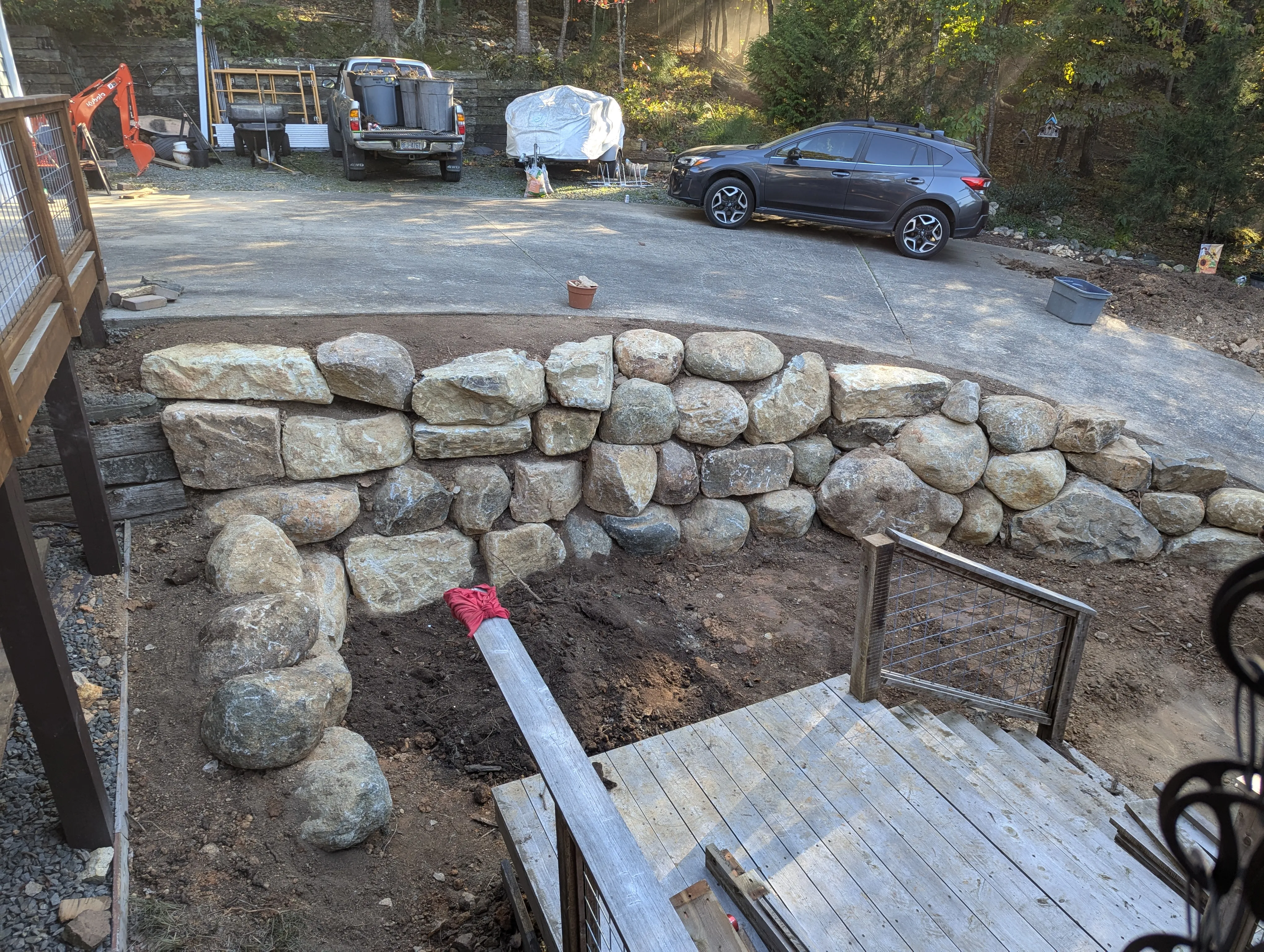 Stacked natural boulder wall with moss and plantings settling into the landscape