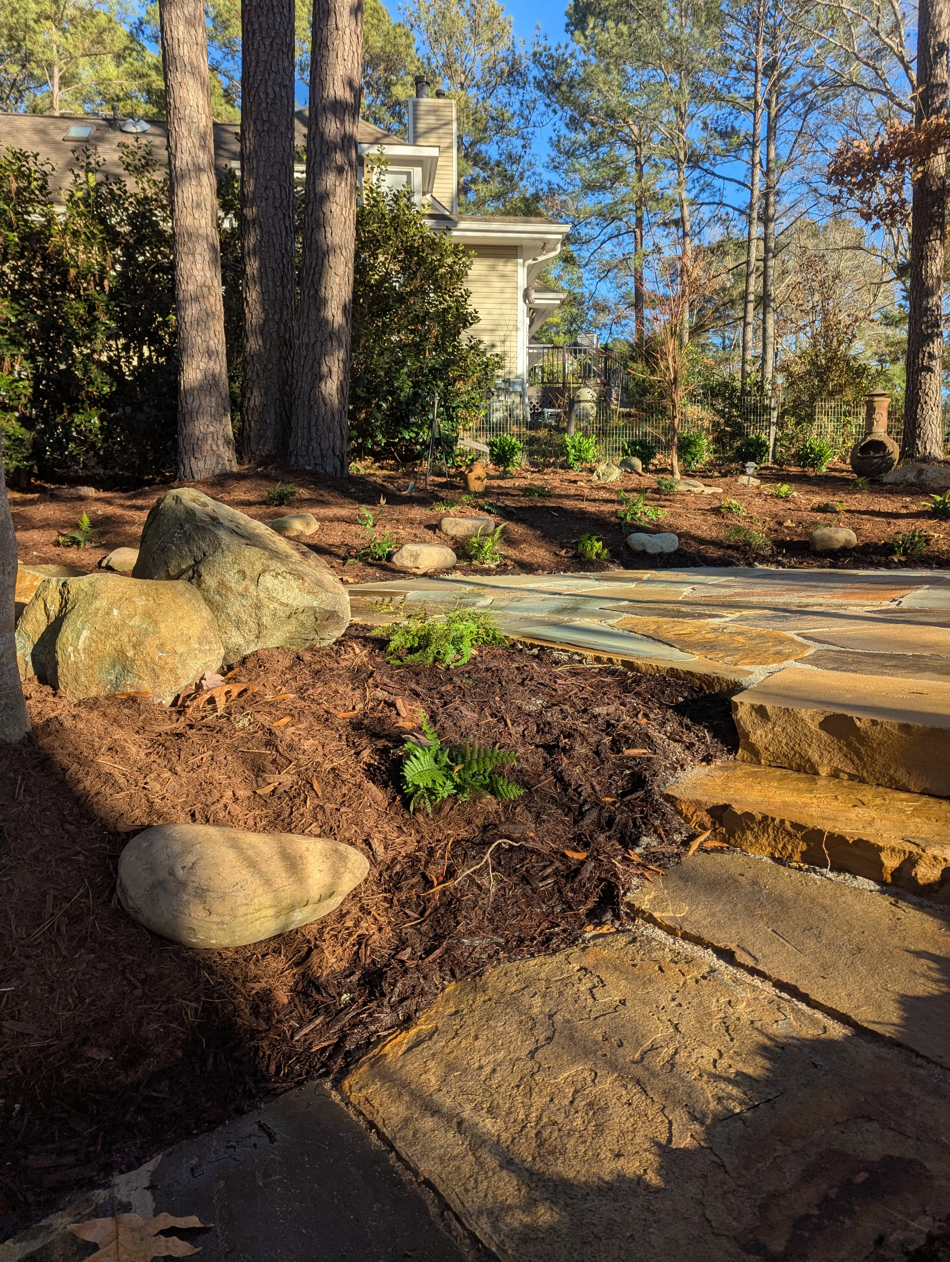 Flagstone patio with a large natural boulder integrated as a design feature