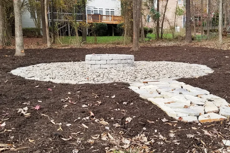Completed stone fire pit in residential backyard
